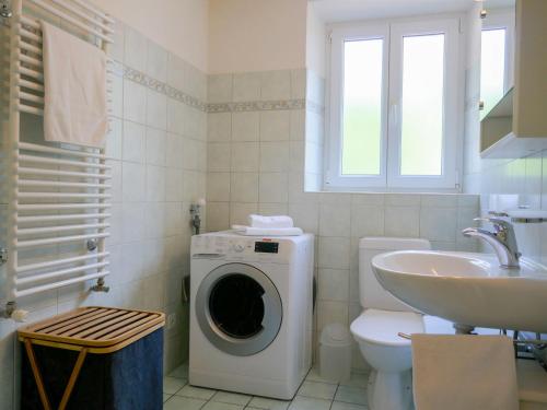 a bathroom with a washing machine and a sink at Holiday Home Ca' Virc by Interhome in Olivone