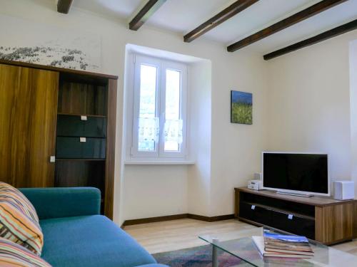 a living room with a blue couch and a tv at Holiday Home Ca' Virc by Interhome in Olivone