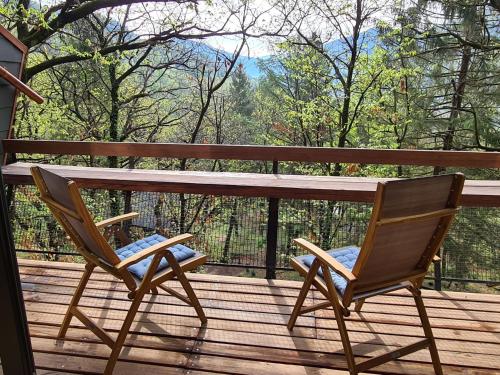 Termine的住宿－Chalet Bosco della Bella - Casa 6 - ZUG by Interhome，木头景甲板上的两把椅子