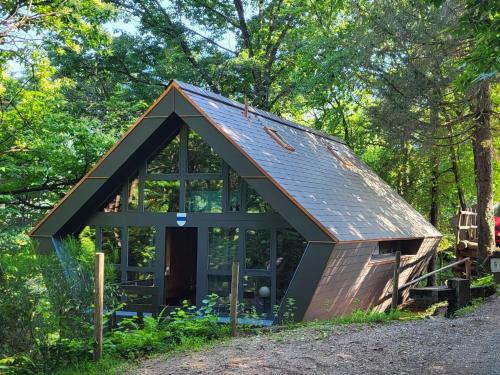 eine kleine Hütte im Wald mit Dachschräge in der Unterkunft Chalet Bosco della Bella - Casa 6 - ZUG by Interhome in Termine
