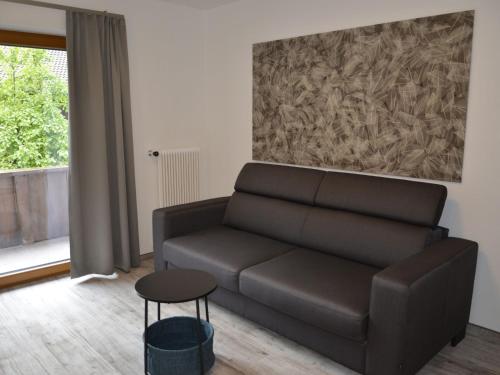 a living room with a couch and a painting at Apartment Apart Hof Achenrainer by Interhome in Landeck