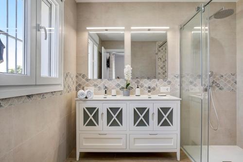 a bathroom with a white vanity and a shower at Marta's Paradise in Conil de la Frontera