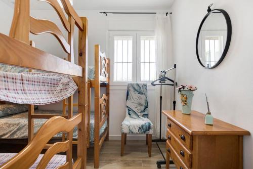 a bedroom with bunk beds and a desk and a mirror at Marta's Paradise in Conil de la Frontera