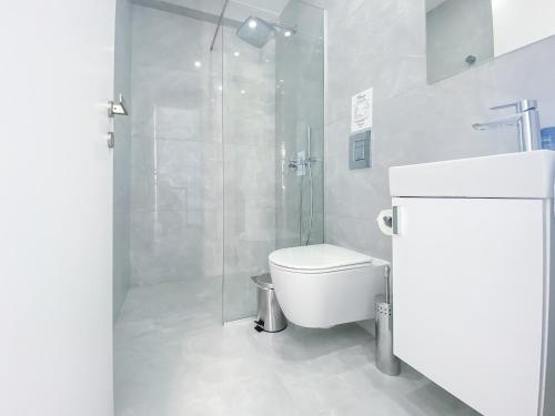 a bathroom with a toilet and a glass shower at Phaedrus Living: Marina Sea View Flat 214 Emerald in Paphos