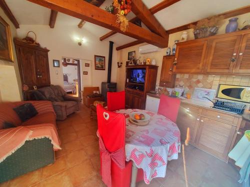 uma cozinha com uma mesa e cadeiras vermelhas num quarto em Villa le thoronet em Le Thoronet
