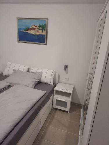 a small bedroom with a bed and a night stand at Apartments Miličević in Gradac