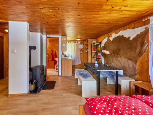 a living room with a wooden ceiling and a table at Holiday Home Lesní plovárna B1 by Interhome in Mladé Buky