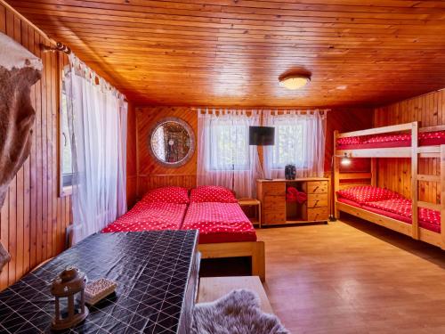 a bedroom with two beds in a wooden cabin at Holiday Home Lesní plovárna B1 by Interhome in Mladé Buky