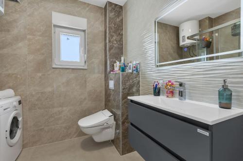 a bathroom with a toilet and a sink and a mirror at Dei apartment in Makarska