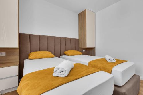 a bedroom with two beds with towels on them at Dei apartment in Makarska