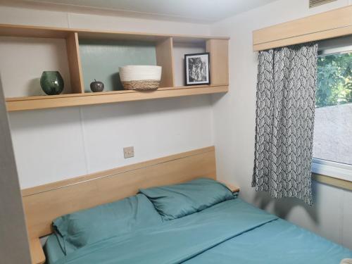 une chambre avec un lit avec des draps bleus et une fenêtre dans l'établissement Dépendance cosy entre jardin et jacuzzi privés et piscine partagée, à Aubagne