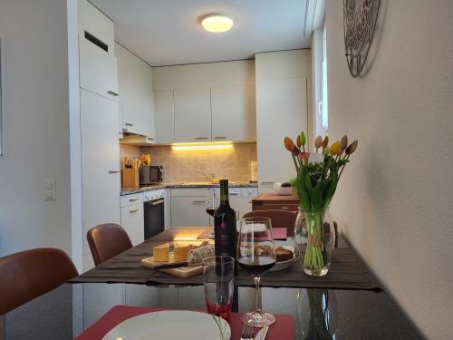 - une cuisine avec une table et une bouteille de vin dans l'établissement Apartment Torre Tessuti 3-2 by Interhome, à Locarno
