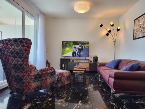 Una sala de estar con un sofá y un televisor. en Apartment Torre Tessuti Apt-Leonardo by Interhome, en Locarno