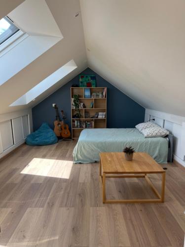 Schlafzimmer im Dachgeschoss mit einem Bett und einem Tisch in der Unterkunft Maison Chessy in Chessy