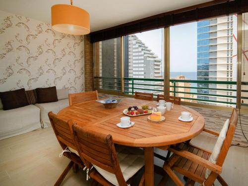 a dining room table with chairs and a large window at Apartment Etxezuri by Interhome in Calpe