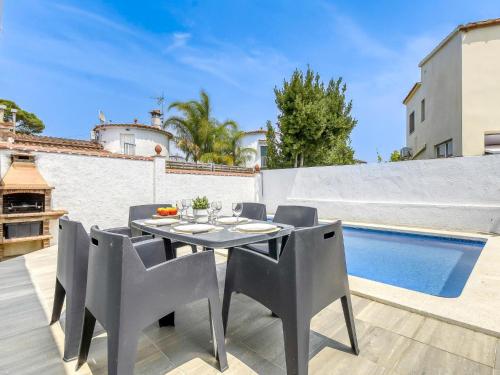 een terras met een tafel en stoelen en een zwembad bij Holiday Home Luna by Interhome in Empuriabrava