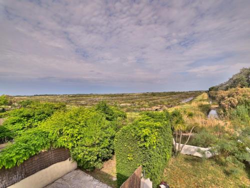 un jardin avec des buissons verts et une clôture dans l'établissement Holiday Home Le Douhet 1 by Interhome, à Saint-Georges-dʼOléron