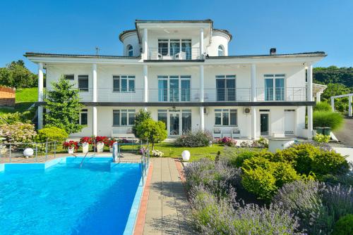 a large white house with a swimming pool in front of it at Apartments Villa Graf in Smederevo