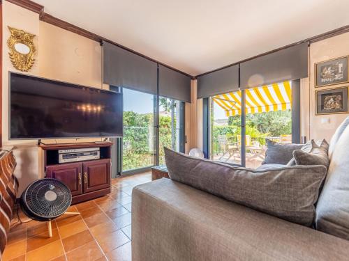 uma sala de estar com um sofá e uma grande televisão em Holiday Home El Garrofer by Interhome em Comarruga