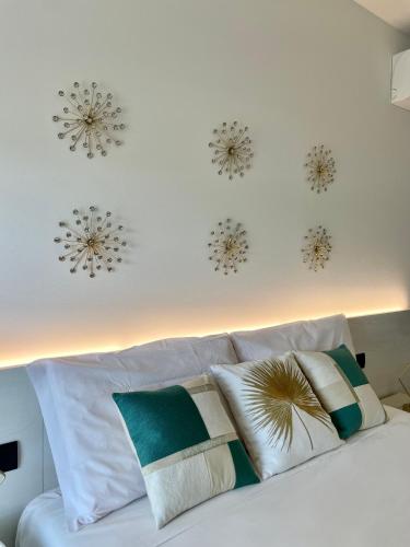 a white bed with pillows and snowflakes on the wall at Milena Suite Apartments in Alghero
