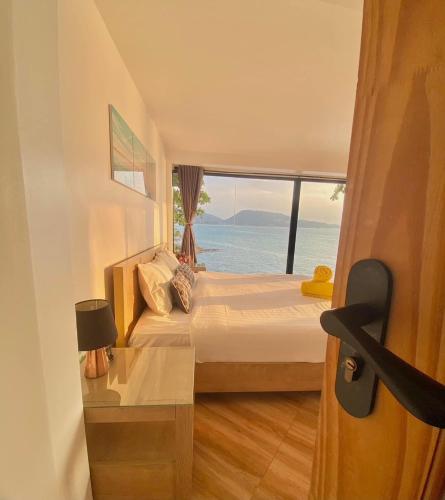 a bedroom with a bed with a view of the ocean at patong sunset villa Phuket in Patong Beach