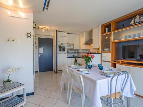 une cuisine et une salle à manger avec une table et des chaises blanches dans l'établissement Apartment Parc de Pontaillac-28 by Interhome, à Vaux-sur-Mer