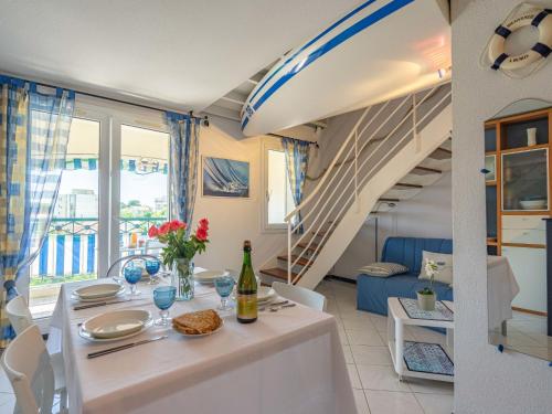 une salle à manger avec une table et un escalier dans l'établissement Apartment Parc de Pontaillac-28 by Interhome, à Vaux-sur-Mer