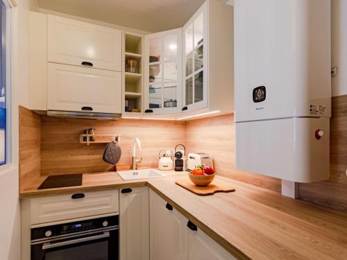 een keuken met witte kasten en een houten aanrechtblad bij Apartment l'Hermitage-3 by Interhome in Deauville
