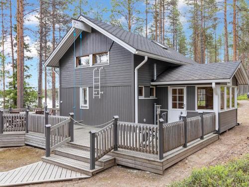 una pequeña casa gris con terraza de madera en Holiday Home Alakitkanranta by Interhome, en Kuusamo