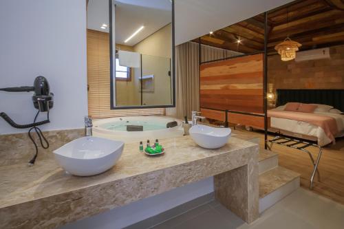 a bathroom with two sinks and a bath tub at Solar Da Serra Tiradentes in Tiradentes