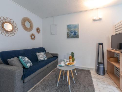sala de estar con sofá azul y mesa en Apartment Les Jardins du Couchant by Interhome en La Grande-Motte