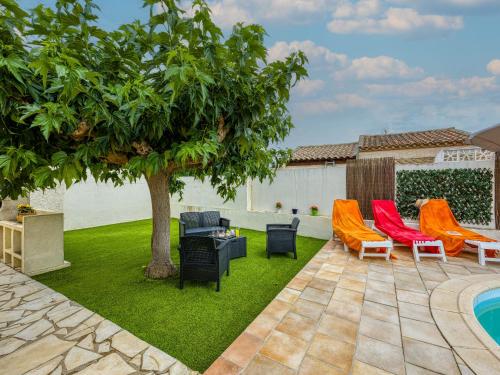 un patio con sillas y un árbol junto a una piscina en Holiday Home La Voie Romaine by Interhome, en Sauvian