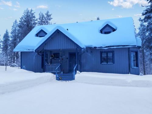 una casa azul con nieve en el techo en Holiday Home Mustikka by Interhome en Kuusamo