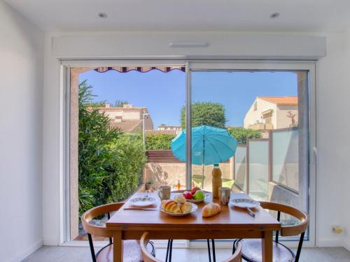 une table avec une assiette de nourriture et un parapluie dans l'établissement Studio Le Mas de la Mer by Interhome, à Saint-Cyr-sur-Mer