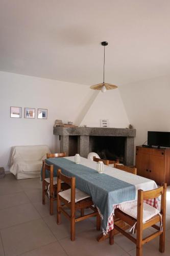 a dining room with a table and chairs and a fireplace at Gutturu de Flumini in Magazzini