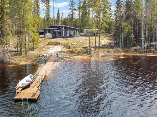 une maison sur un lac avec un quai et un bateau dans l'établissement Holiday Home Metsäpirtti by Interhome, à Keuruu
