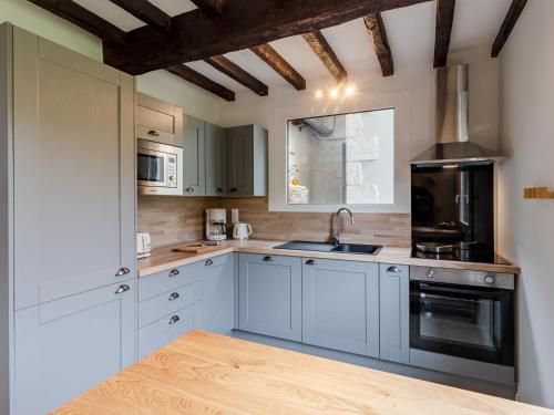 a kitchen with white cabinets and a sink and a stove at Holiday Home La Normande by Interhome in Touques