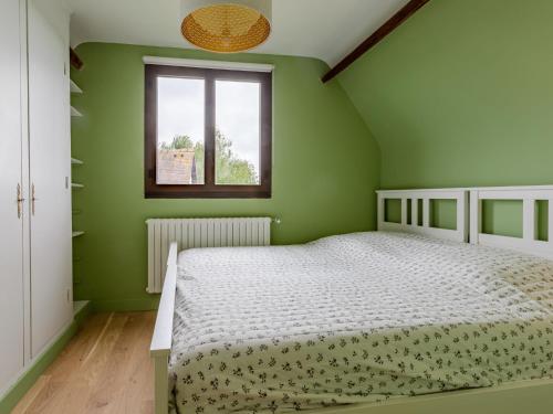 a green bedroom with a bed and a window at Holiday Home La Normande by Interhome in Touques