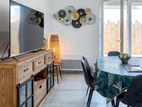 une salle à manger avec une table et une télévision dans l'établissement Holiday Home La Villa Dorée by Interhome, à Pornic