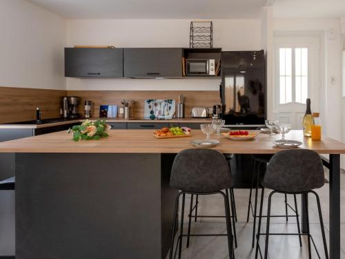 une cuisine avec un grand îlot et des tabourets de bar dans l'établissement Holiday Home La Villa Dorée by Interhome, à Pornic