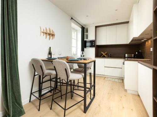 une cuisine avec une table et des chaises dans une pièce dans l'établissement Apartment Le Prieuré by Interhome, à Dinard