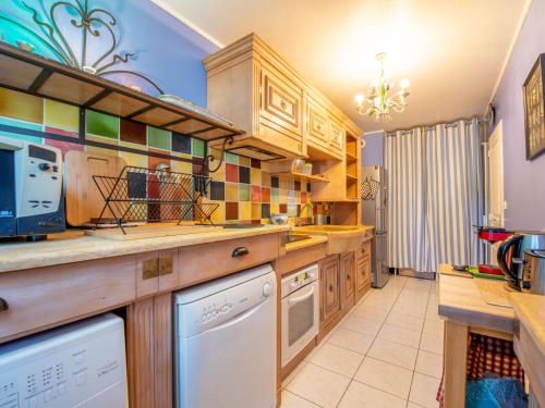 - une cuisine avec des placards en bois et un lave-vaisselle blanc dans l'établissement Apartment Le Cap Sud by Interhome, à Cavalaire-sur-Mer