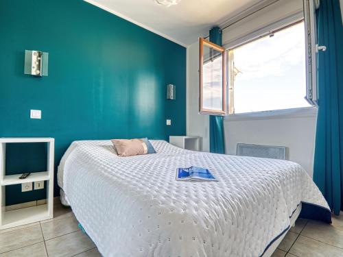 une chambre avec un lit et un mur bleu dans l'établissement Apartment Fleurie by Interhome, à Fréjus