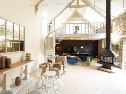 ein Wohnzimmer mit einem Kamin und einer Treppe in der Unterkunft Holiday Home La Gentilhommière by Interhome in Le Tronchet