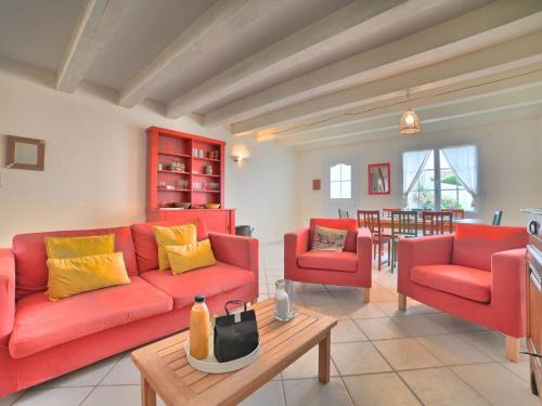 een woonkamer met een rode bank en 2 stoelen bij Holiday Home Matha by Interhome in Saint-Pierre-dʼOléron