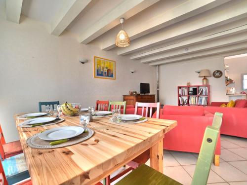 een eetkamer met een houten tafel en een rode bank bij Holiday Home Matha by Interhome in Saint-Pierre-dʼOléron