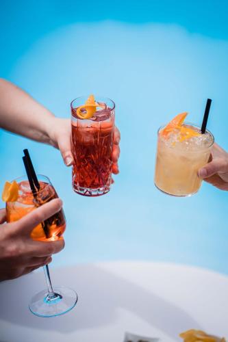 a group of people holding cocktails in their hands at Hotel Calanca in Marina di Camerota
