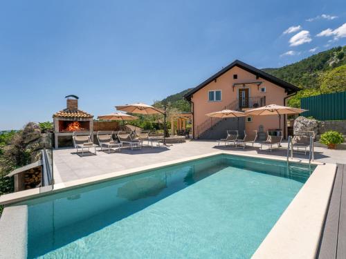 eine Villa mit einem Pool und einem Haus in der Unterkunft Holiday Home Zgodić by Interhome in Lovran