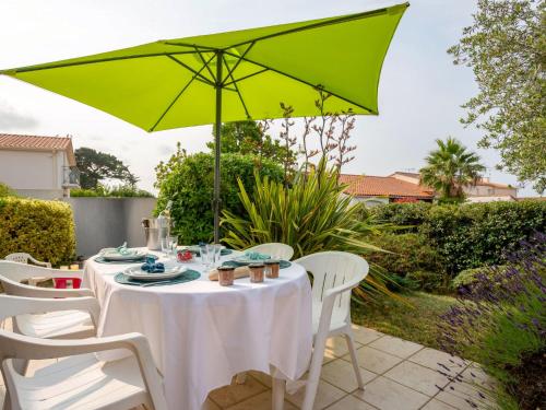 - une table avec un parasol vert sur la terrasse dans l'établissement Holiday Home Plein Océan-1 by Interhome, à Pornic