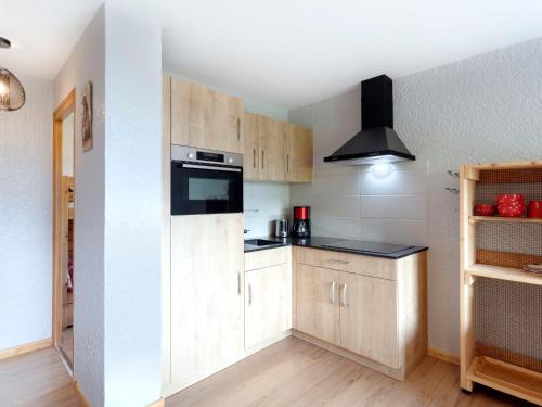 uma cozinha com armários de madeira e um balcão preto em Studio Les Tétras by Interhome em Saint-Gervais-les-Bains